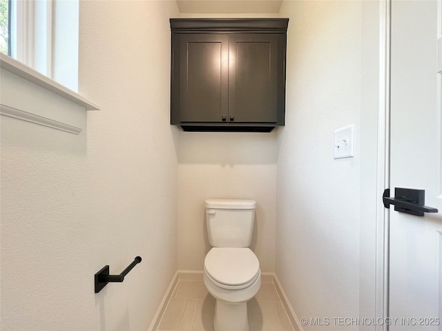 bathroom featuring tile patterned floors, toilet, and baseboards