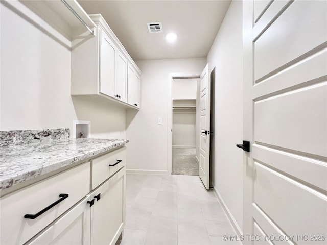 laundry room featuring washer hookup, visible vents, cabinet space, and baseboards
