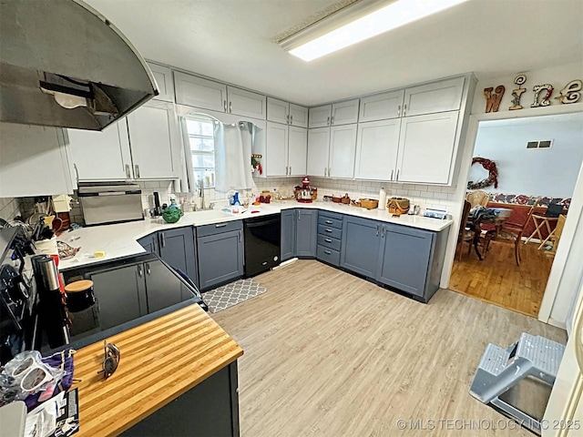 kitchen with range hood, light wood-type flooring, dishwasher, gray cabinetry, and light countertops