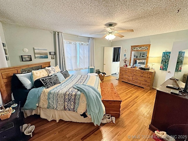 bedroom featuring a ceiling fan, a textured ceiling, and light wood-type flooring