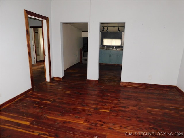 unfurnished bedroom featuring baseboards and dark wood finished floors