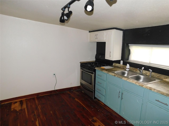 kitchen featuring stainless steel gas range, dark wood-type flooring, blue cabinetry, and a sink