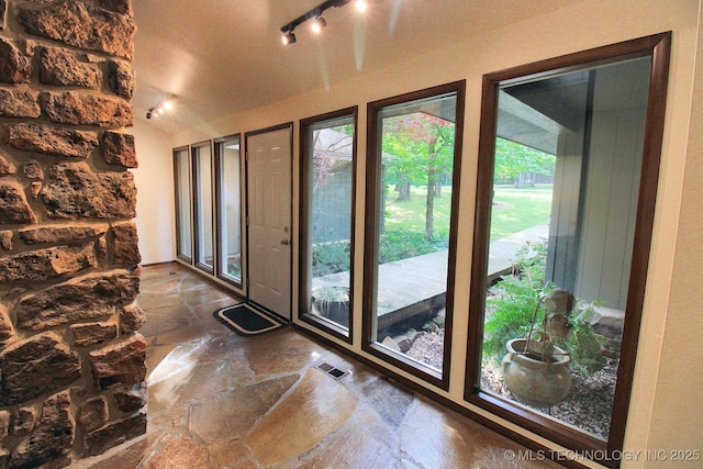entryway with stone flooring and rail lighting