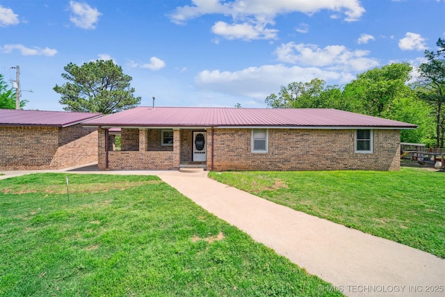 ranch-style house with covered porch, brick siding, a front lawn, and metal roof