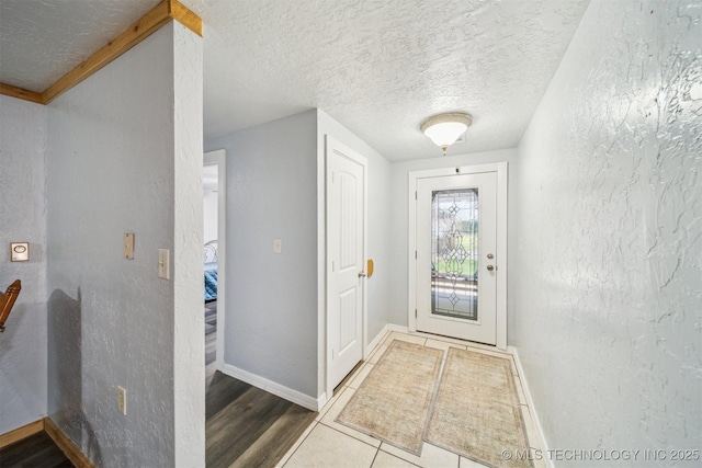 interior space featuring a textured ceiling, wood finished floors, and baseboards