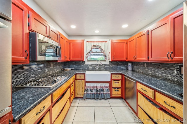 kitchen with tasteful backsplash, stainless steel appliances, light tile patterned flooring, and a sink