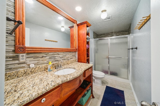 bathroom with backsplash, vanity, baseboards, visible vents, and a stall shower