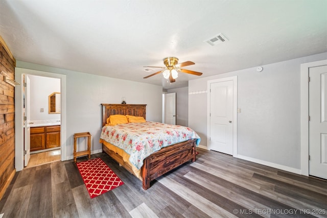 bedroom with connected bathroom, visible vents, dark wood-style floors, baseboards, and a ceiling fan