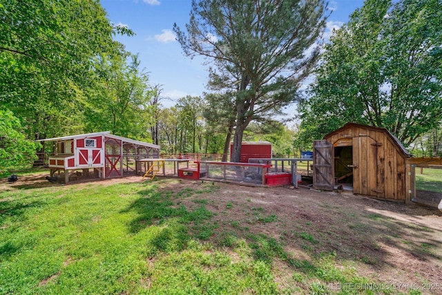 view of yard with fence, an outdoor structure, exterior structure, and a storage shed