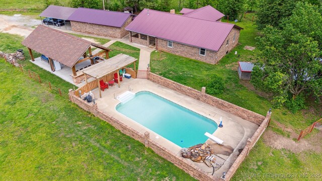 outdoor pool with a yard, a diving board, fence, a gazebo, and a patio
