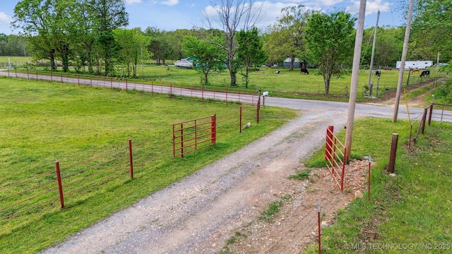 view of road featuring a rural view and dirt driveway