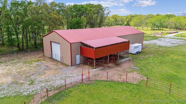 view of outbuilding featuring a rural view, an exterior structure, an outbuilding, and driveway