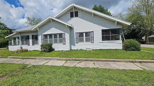 view of home's exterior with a lawn and a sunroom