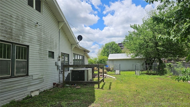 view of yard with central AC and fence
