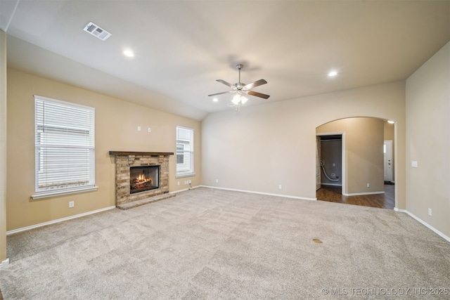 12314 N 131st E Ave, Collinsville, OK 74021 - unfurnished living room with arched walkways, a ceiling fan, carpet floors, baseboards, and a fireplace