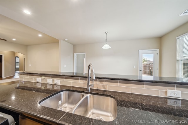 12314 N 131st E Ave, Collinsville, OK 74021 - kitchen featuring a sink, arched walkways, dark stone counters, recessed lighting, and pendant lighting