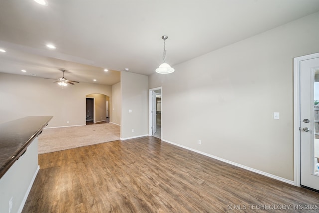12314 N 131st E Ave, Collinsville, OK 74021 - unfurnished living room featuring wood finished floors, arched walkways, recessed lighting, baseboards, and a ceiling fan