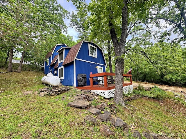 exterior space featuring a gambrel roof and a wooden deck
