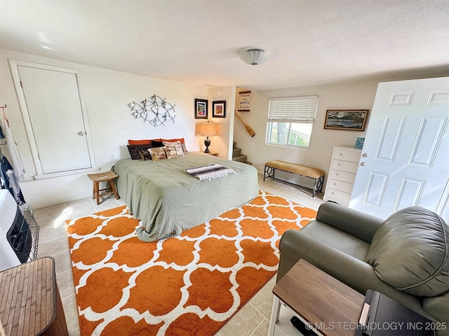 bedroom with a textured ceiling and tile patterned floors