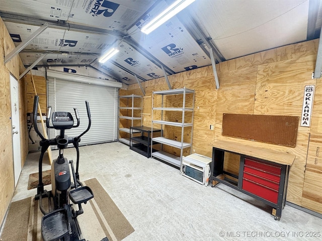 workout area with a workshop area, wooden walls, and lofted ceiling