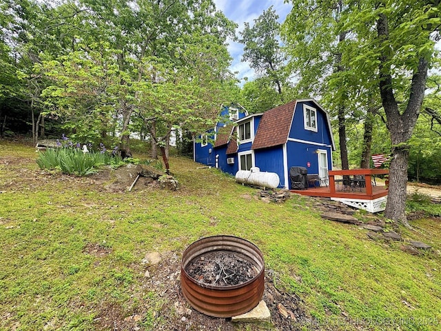 view of yard with an outdoor fire pit and a wooden deck