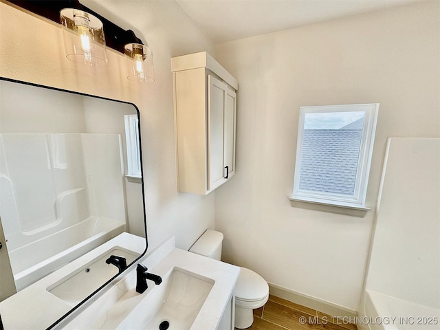 bathroom featuring baseboards, vanity, toilet, and wood finished floors