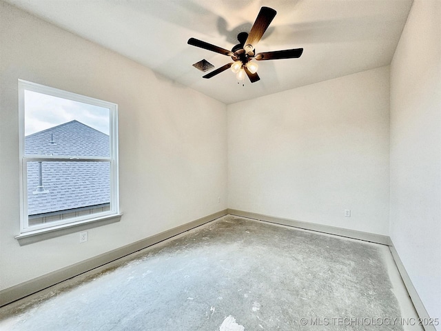 spare room with concrete flooring, ceiling fan, visible vents, and baseboards