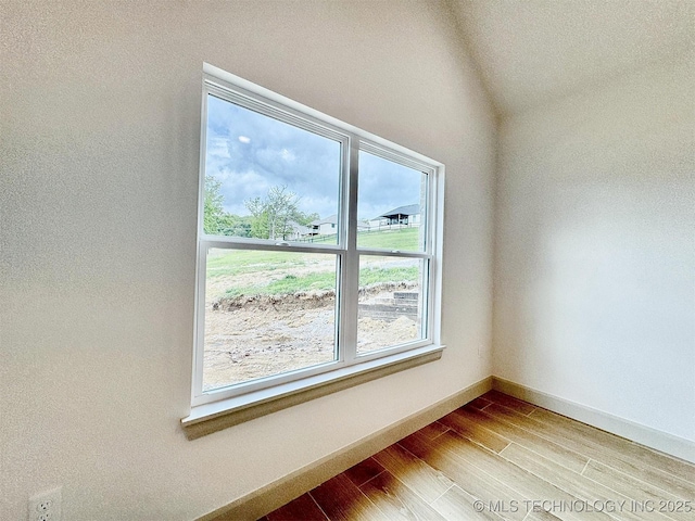 empty room featuring baseboards and wood finished floors
