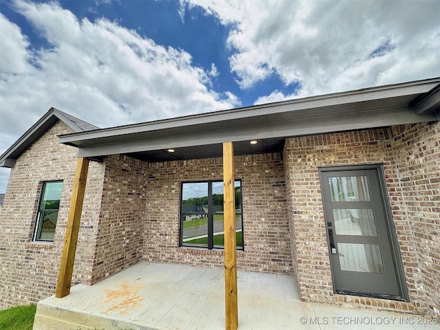 566 Woodlands Dr, Tahlequah, OK 74464 - view of exterior entry with a patio area and brick siding