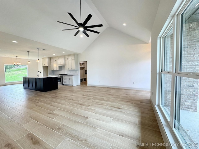 566 Woodlands Dr, Tahlequah, OK 74464 - unfurnished living room featuring a sink, wood finish floors, ceiling fan, a chandelier, and baseboards