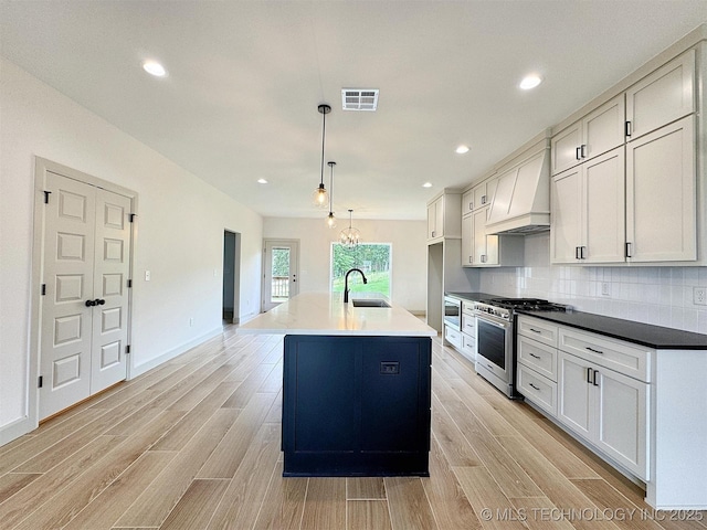 566 Woodlands Dr, Tahlequah, OK 74464 - kitchen with high end range, a sink, custom exhaust hood, light wood-style flooring, and recessed lighting