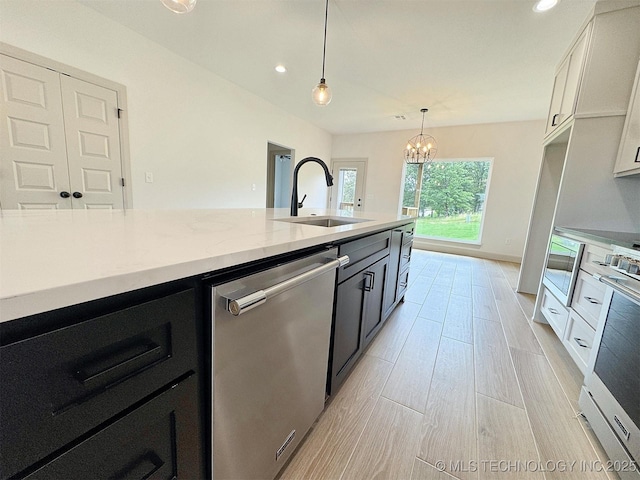 566 Woodlands Dr, Tahlequah, OK 74464 - kitchen featuring a sink, appliances with stainless steel finishes, dark cabinets, decorative light fixtures, and a chandelier