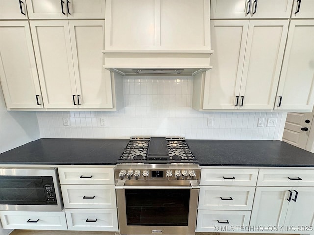 566 Woodlands Dr, Tahlequah, OK 74464 - kitchen featuring appliances with stainless steel finishes, dark countertops, white cabinets, decorative backsplash, and ventilation hood