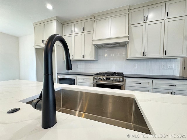 566 Woodlands Dr, Tahlequah, OK 74464 - kitchen featuring high end stainless steel range, premium range hood, decorative backsplash, dark stone counters, and recessed lighting