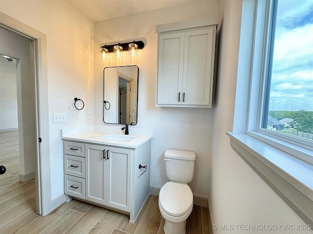 566 Woodlands Dr, Tahlequah, OK 74464 - bathroom featuring vanity, toilet, baseboards, and wood finished floors