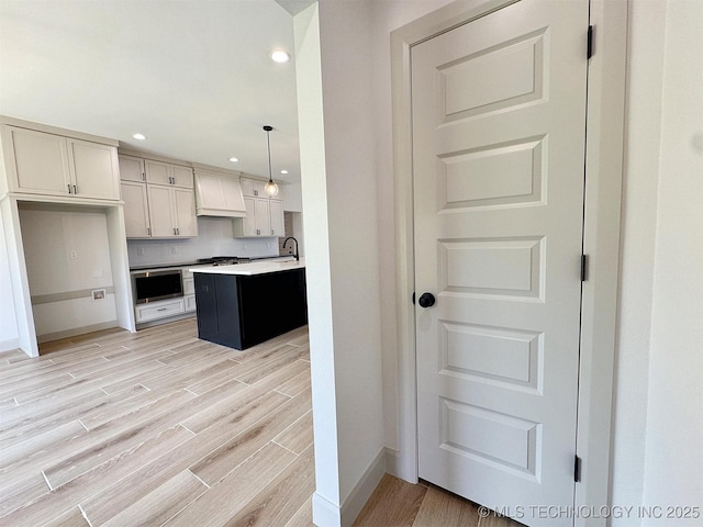 566 Woodlands Dr, Tahlequah, OK 74464 - kitchen featuring light wood finished floors, recessed lighting, baseboards, light countertops, and decorative backsplash