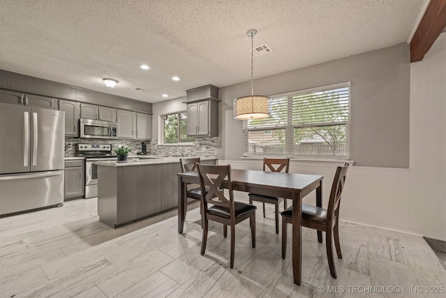 dining space with a textured ceiling, visible vents, and recessed lighting
