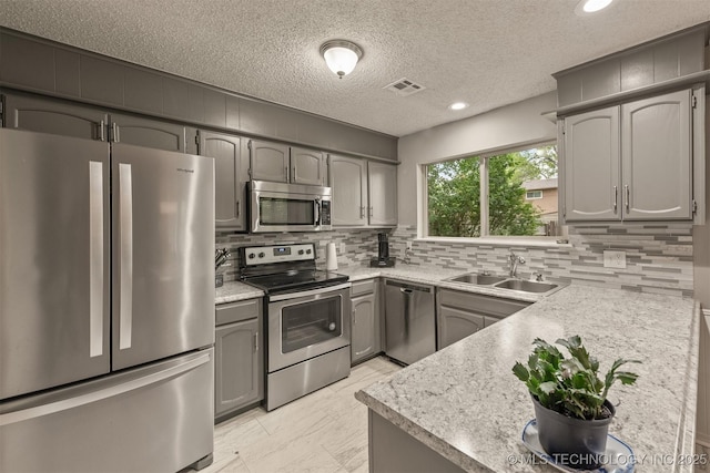 kitchen featuring visible vents, a sink, appliances with stainless steel finishes, and tasteful backsplash