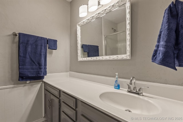 bathroom with a shower stall and vanity