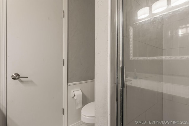 full bathroom with a stall shower and toilet