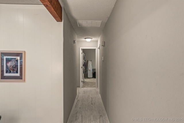 hall with visible vents and a textured ceiling