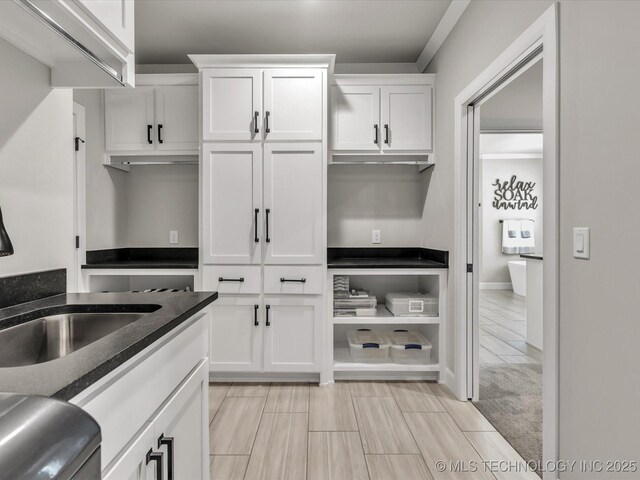 13651 S 26th St, Jenks, OK 74008 - kitchen featuring a sink, white cabinets, dark stone counters, and baseboards