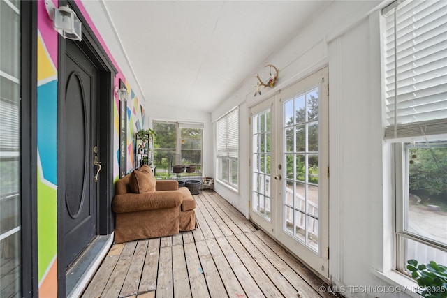 sunroom / solarium with hardwood / wood-style floors and french doors