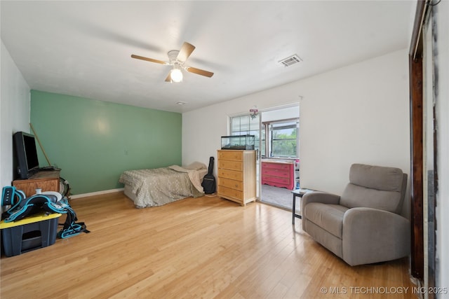 bedroom with a ceiling fan, visible vents, and wood finished floors