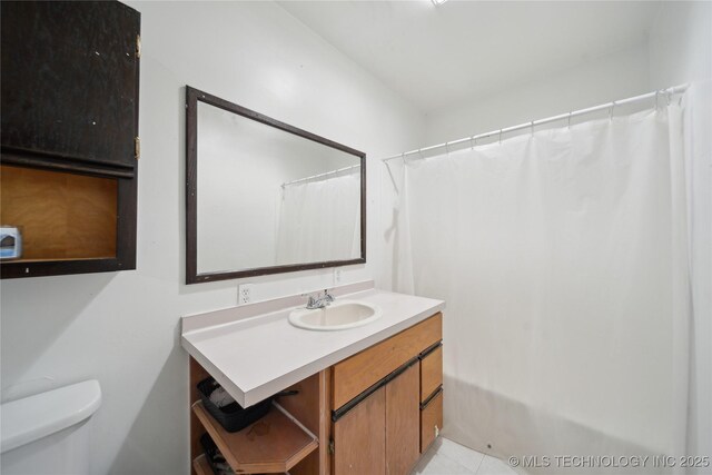 full bathroom featuring curtained shower, toilet, tile patterned flooring, and vanity