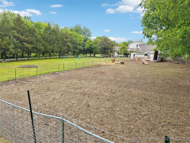 view of community featuring fence and a yard