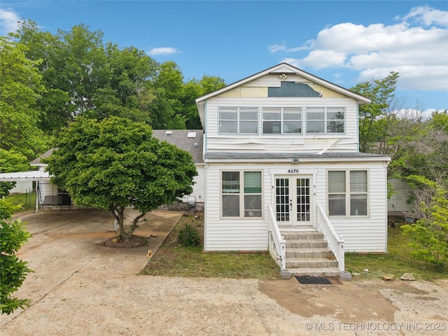 view of front of home with roof with shingles, entry steps, and french doors