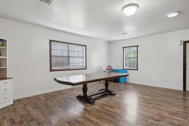 office area featuring baseboards, visible vents, and wood finished floors