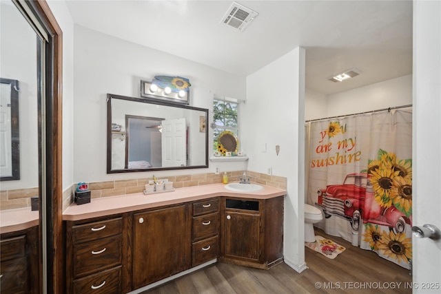 full bath featuring wood finished floors, visible vents, toilet, and vanity