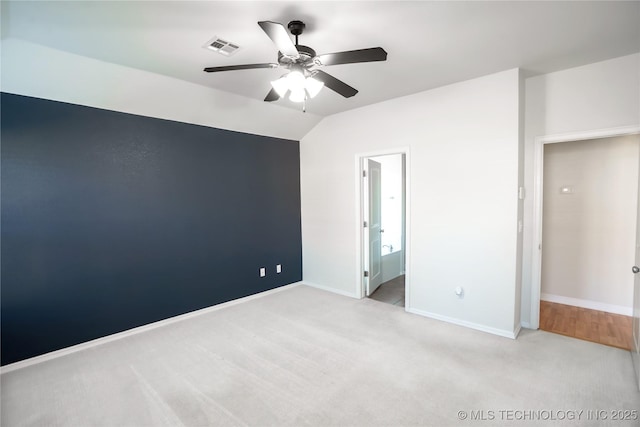 unfurnished room featuring ceiling fan, visible vents, baseboards, lofted ceiling, and light carpet